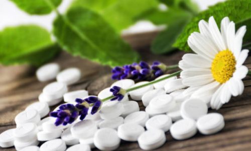 Schuessler salts and herbs against a wooden background